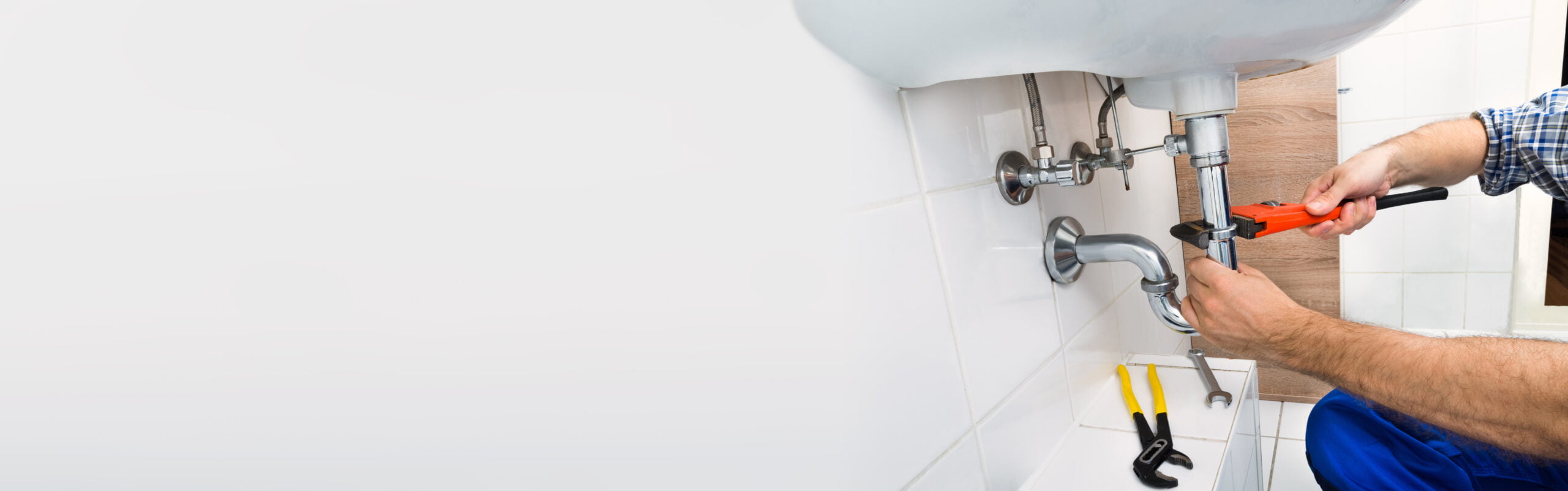 Close-up Of Male Plumber Fixing Sink In Bathroom